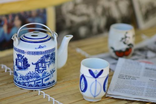 Free Blue and white Chinese teapot with cups on bamboo surface, evoking art and tradition. Stock Photo