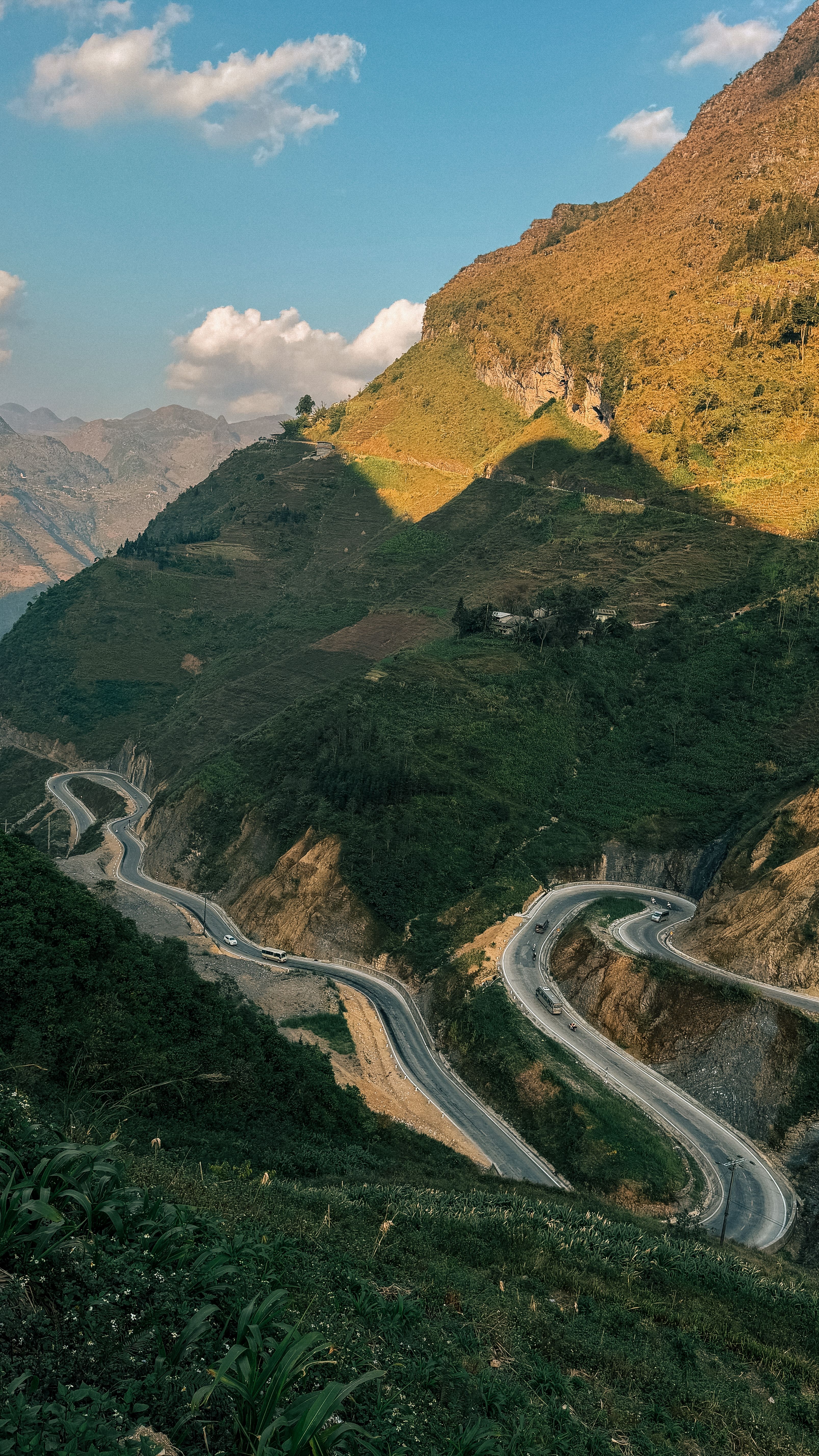 A picturesque serpentine road through lush hills in Hà Giang, Vietnam.