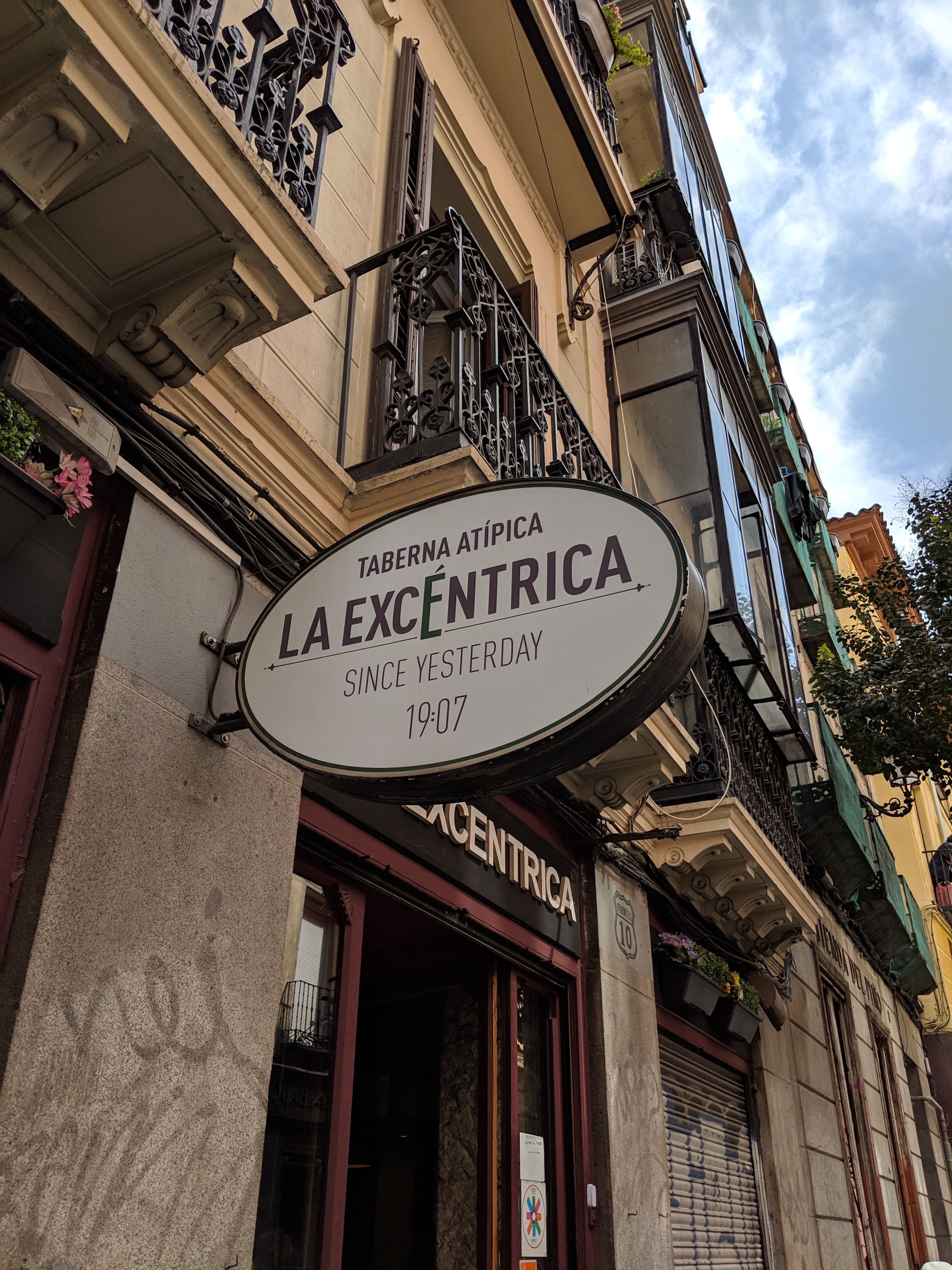 Explore the lively streets of Madrid with this view of 'La Excéntrica' tavern, showcasing European charm.