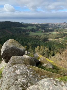 Breathtaking view of Galicia's rocky hills with ocean in the background.
