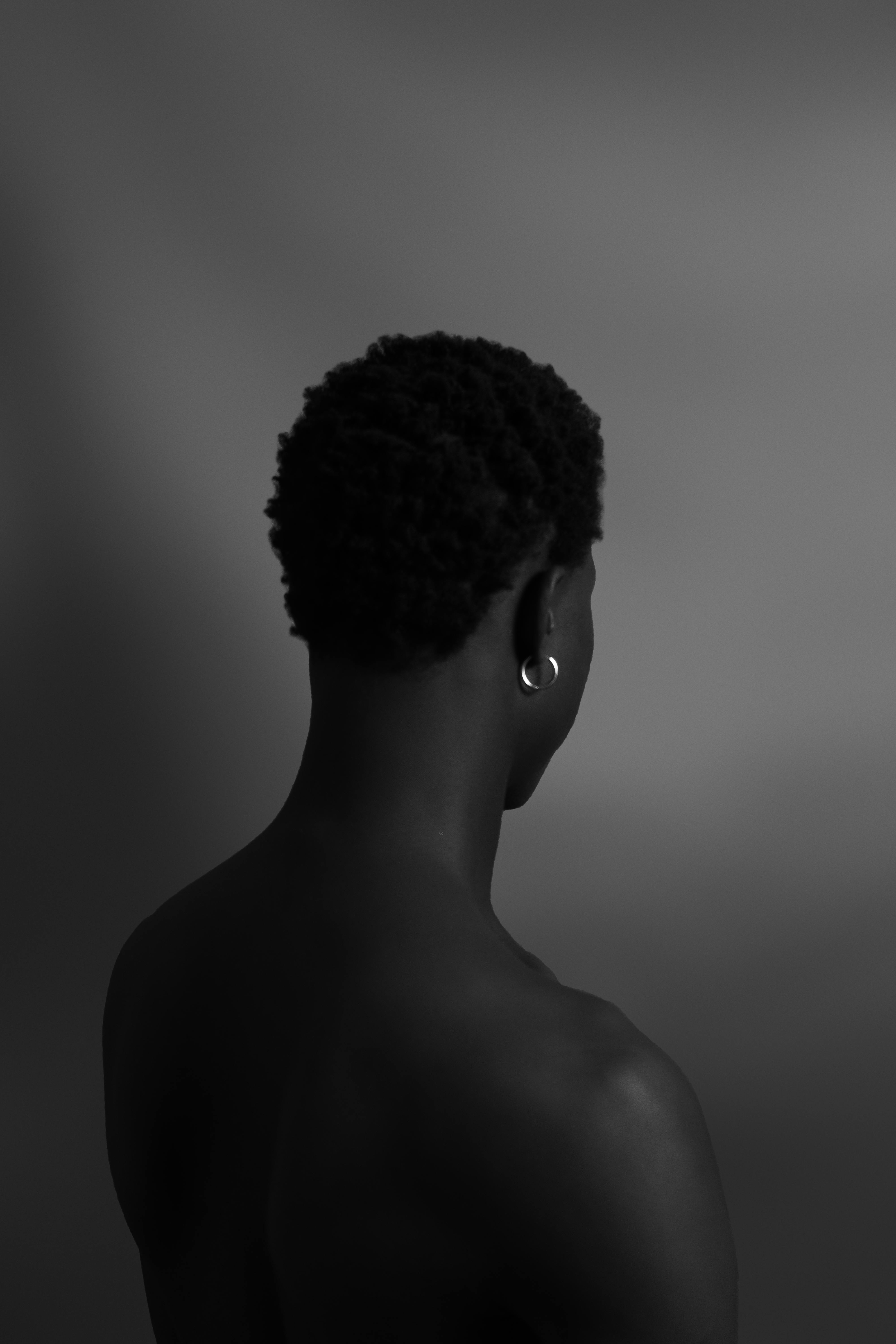 Free Black and white artistic portrait of a black male with back to camera. Stock Photo