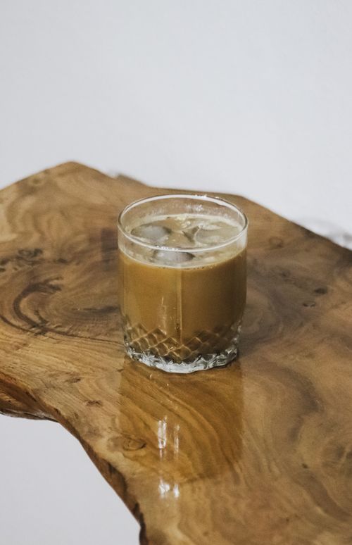 Free Close-up of a refreshing iced coffee on a rustic wooden table, perfect for a caffeine fix. Stock Photo