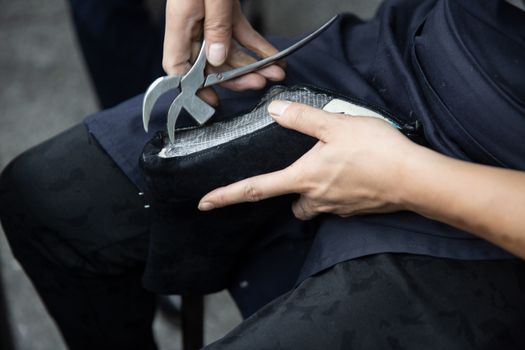 A Person Making Leather Boots Shoes