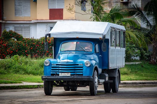 Classic blue vintage truck parked on a city street, showcasing retro design.