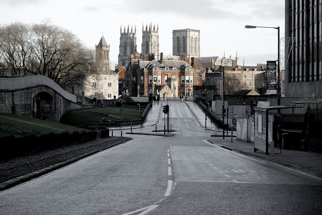 Brown Buildings on End of Road Under Cloudy Sky