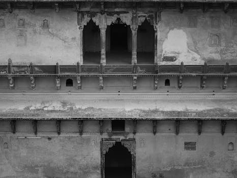 Black and white photo of ancient architectural details in Madhya Pradesh, showcasing intricate stone craftsmanship.