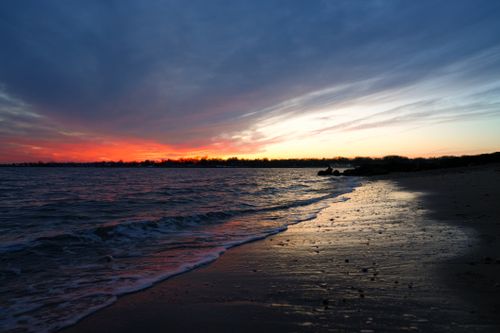 Free Captivating beach sunset showcasing vibrant colors and gentle waves. Stock Photo