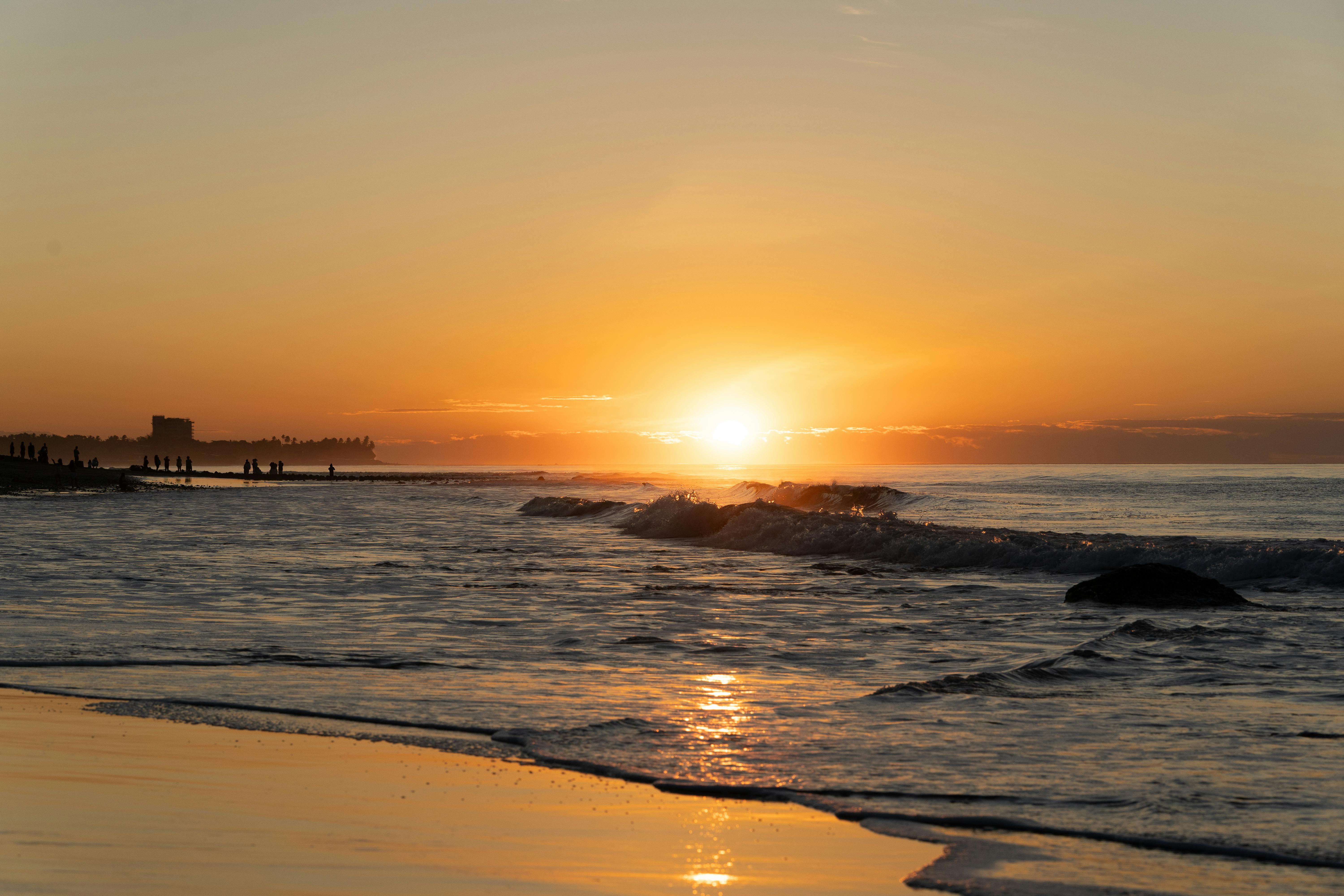 Stunning sunset over the waves at El Tunco beach, capturing vibrant colors and silhouettes.