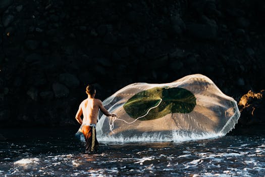 A fisherman skillfully casts his net in the early morning light at El Tunco Beach.