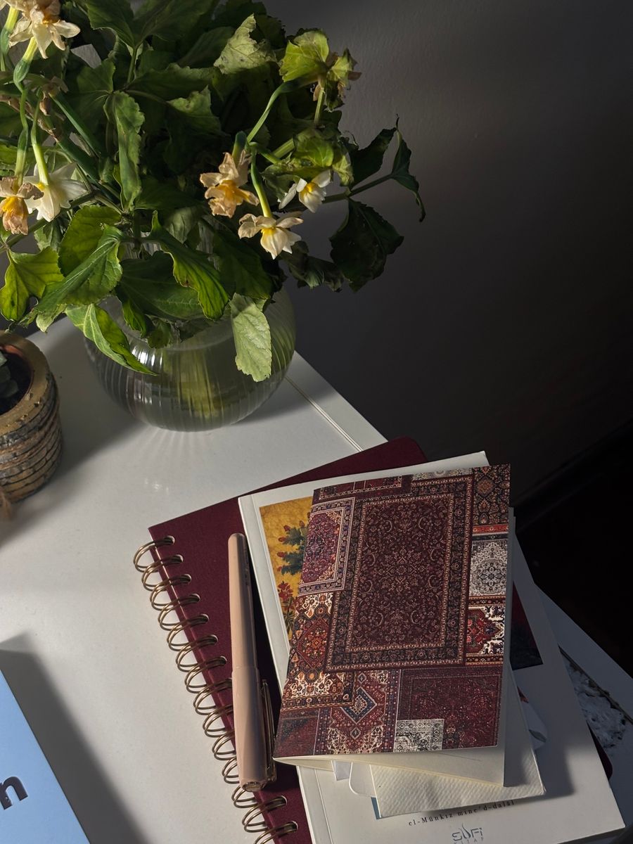 Cozy desk with flowers notebooks and a pen