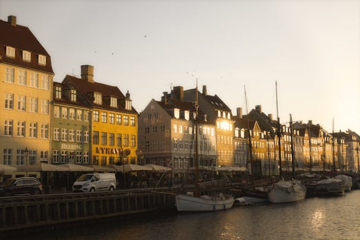 Peaceful morning view of Nyhavn Canal with colorful buildings and boats in Copenhagen, Denmark.