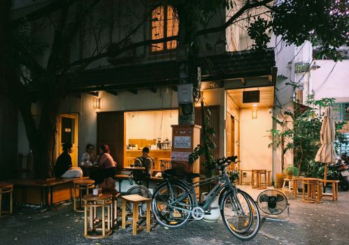Warm evening at a Vietnamese cafe in Ho Chi Minh City with patrons dining outdoors.