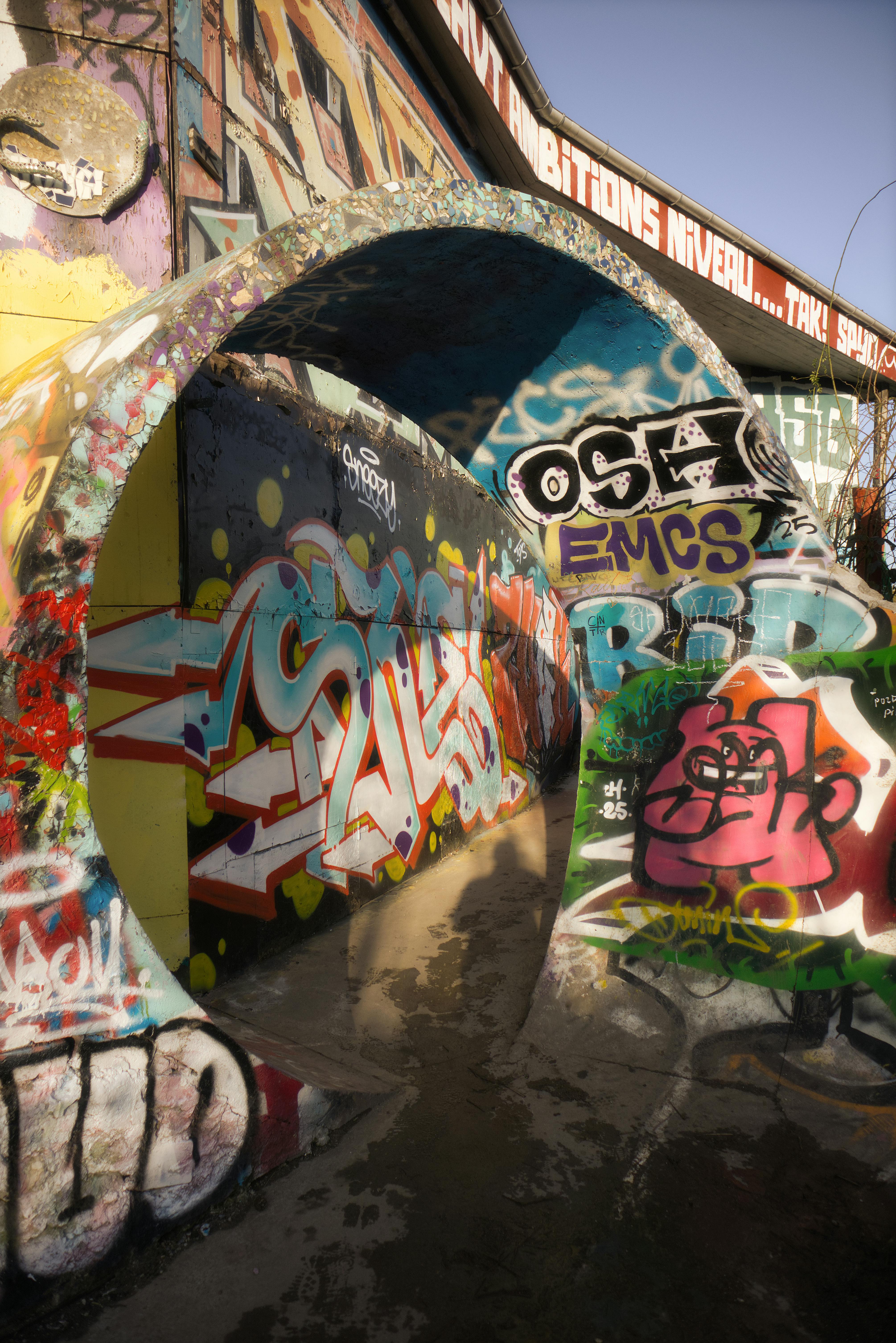 Explore a vivid graffiti tunnel in Copenhagen with colorful street art.