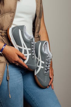 Casual chic with gray sneakers, denim jeans, and beige vest. Perfect blend for everyday fashion.