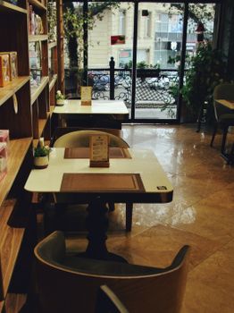 Inviting urban cafe with empty tables ready for diners, offering a warm setting for an intimate meal.