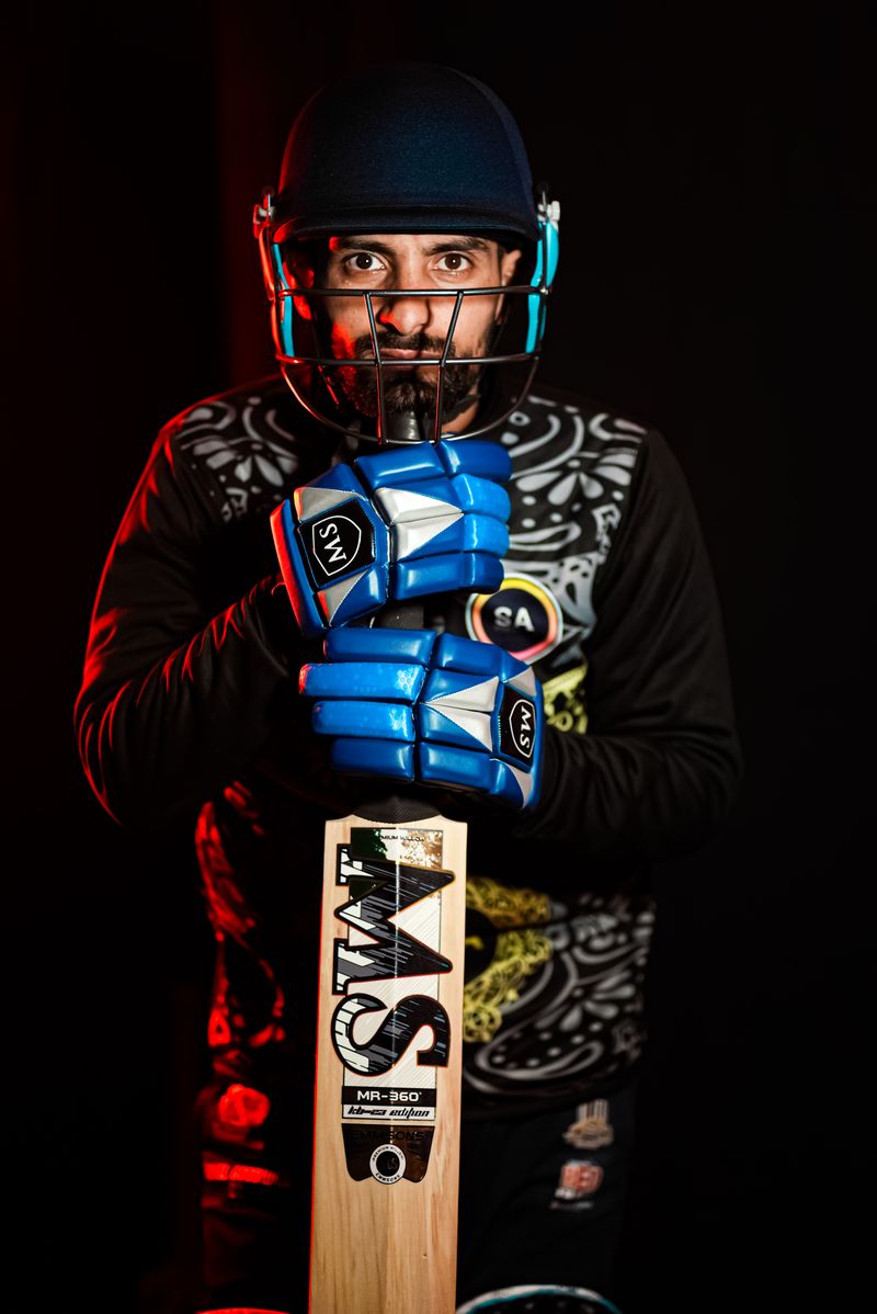 Portrait of a professional cricketer in helmet and gloves holding a bat