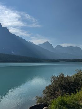 A breathtaking view of Bow Lake surrounded by the majestic Canadian Rockies under a clear blue sky.
