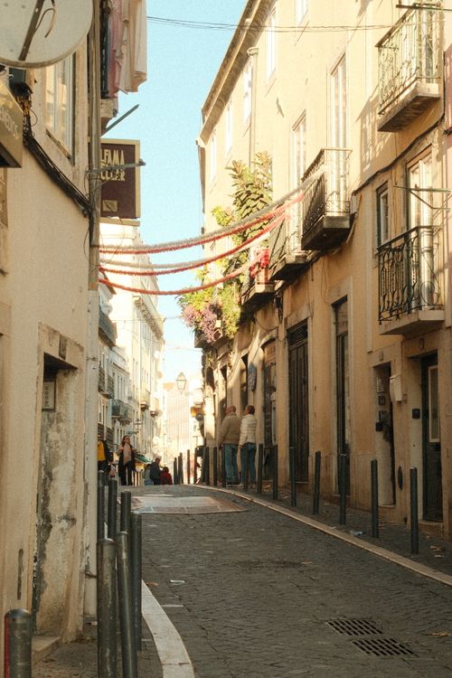 Free Explore a picturesque street in Lisbon, Portugal with hanging decorations and historic architecture. Stock Photo