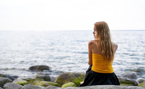 Free Woman in contemplation by the sea in Tallinn, Estonia, capturing a peaceful and serene moment. Stock Photo