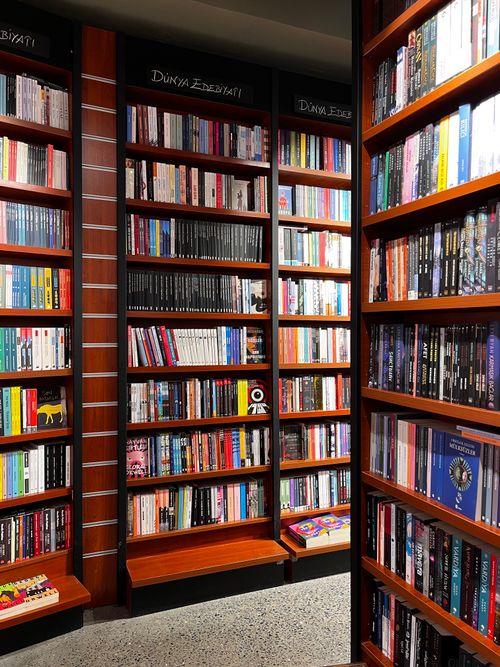 Free Cozy bookstore scene with wooden shelves filled with diverse books. Stock Photo