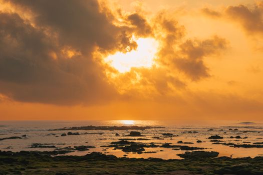 Beautiful orange sunset over a rocky coast in Quảng Trị, Vietnam.