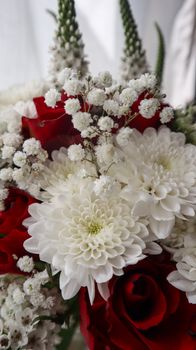 Close-up of a beautiful floral bouquet with white chrysanthemums and red roses, perfect for weddings or events.