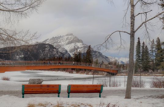 Scenic winter scene of a snowy landscape with a bridge in Banff National Park.