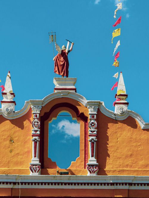 Free Vibrant colonial building façade with statues and flags in Puebla, Mexico. Stock Photo