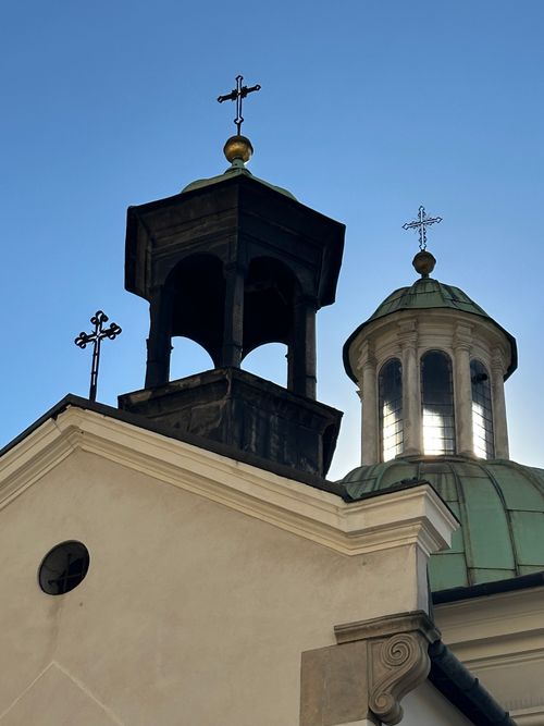 Free Close-up of a historic church dome and bell tower in Krakow, Poland, against a clear blue sky. Stock Photo