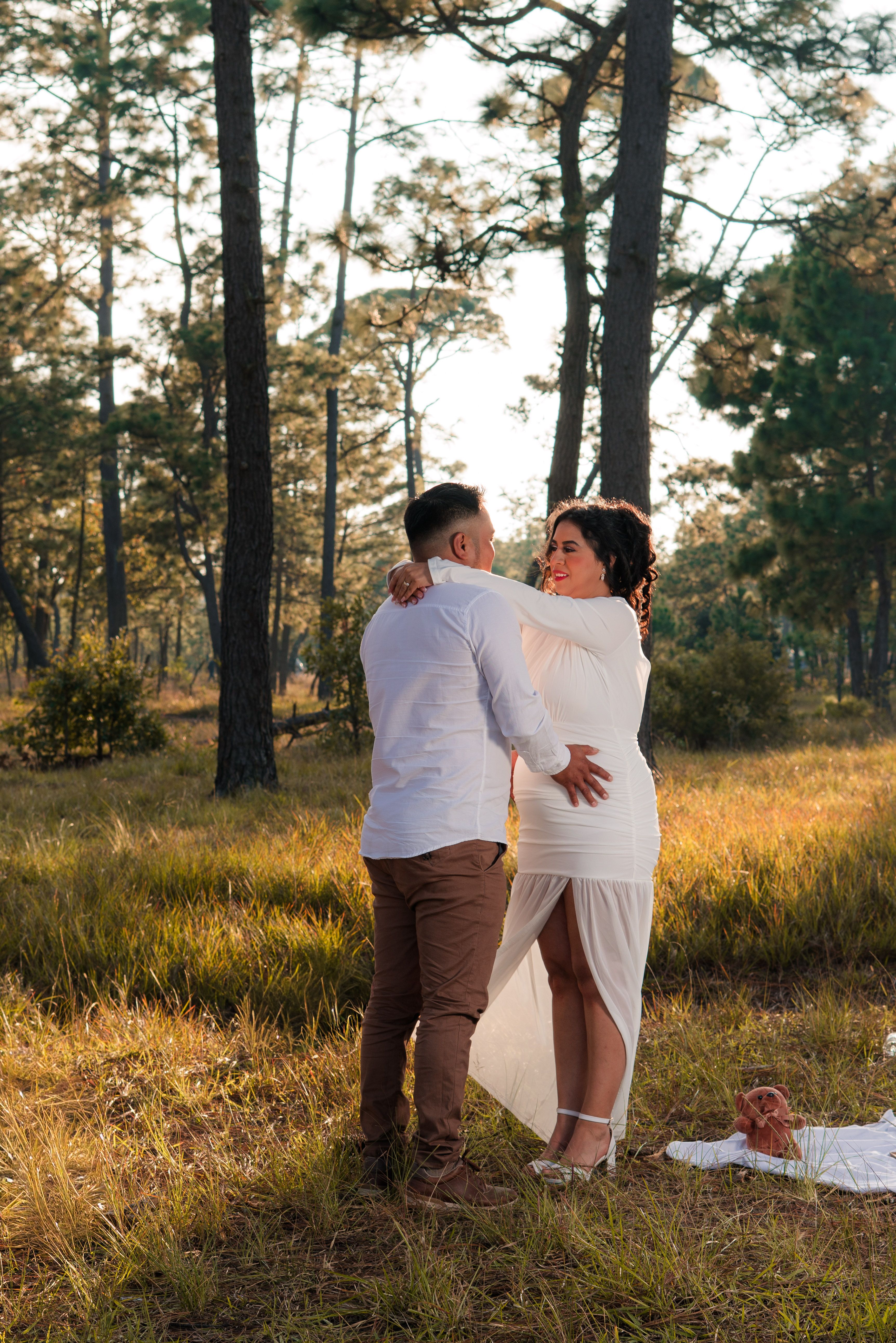Romantic Couple Embracing in Sunlit Forest · Free Stock Photo