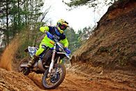 Man Riding Blue and White Dirt Bike