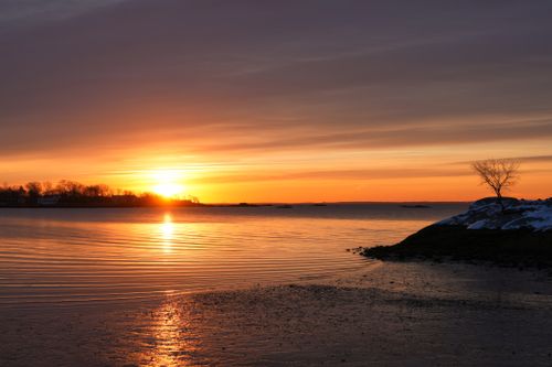 Free Beautiful sunset with a vibrant sky reflecting on calm waters. Stock Photo