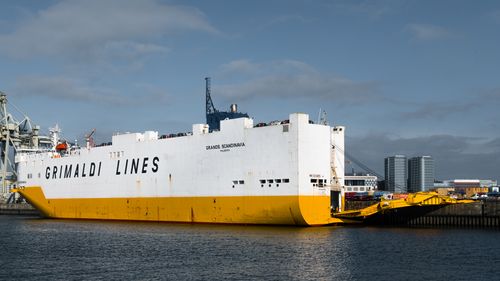 Free Grimaldi Lines cargo ship docked at Hamburg harbor, showcasing marine industry strength. Stock Photo
