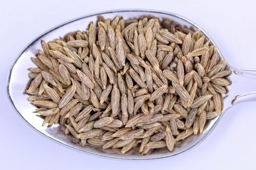 Free High-resolution image of cumin seeds on a metal spoon, perfect for culinary uses. Stock Photo