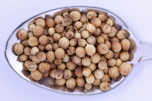 Free Macro shot of whole coriander seeds in a spoon, highlighting texture and detail. Stock Photo