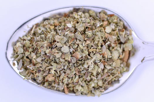 Detailed image of marjoram seasoning in a metal teaspoon, perfect for culinary uses.