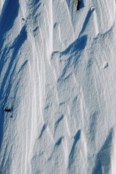 Detailed view of snow texture with shadow effects and crisp surface patterns.