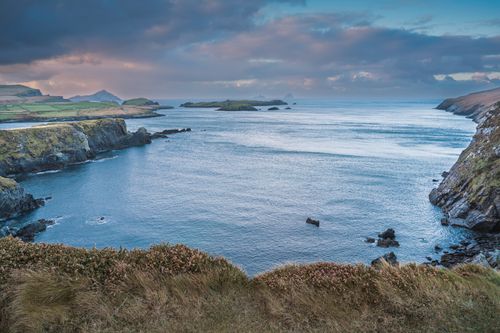 Free A stunning view of the Irish coast at twilight, showcasing the rugged cliffs and expansive ocean. Stock Photo
