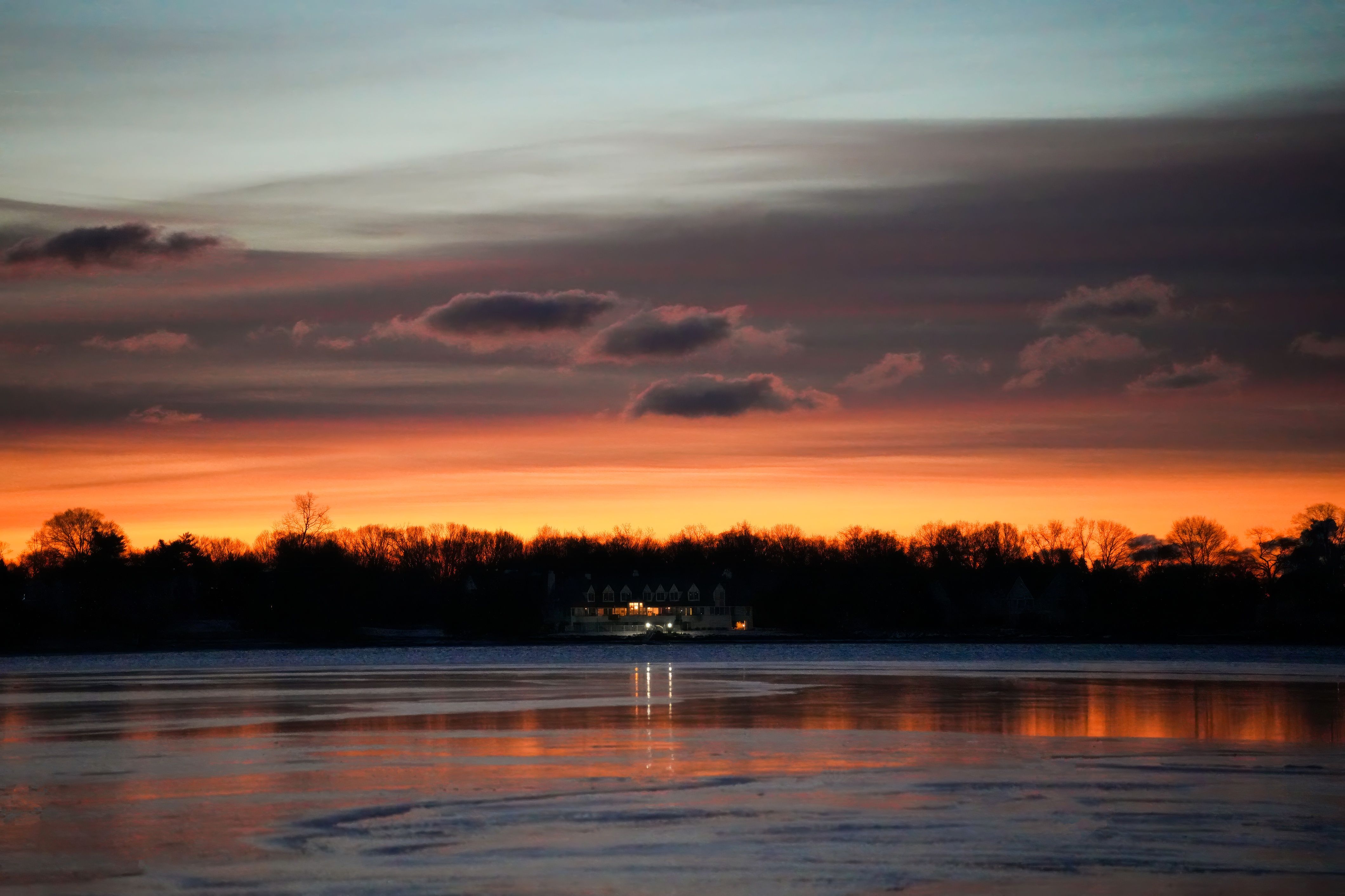 Serene Sunset Over Frozen Lake with Silhouetted Trees · Free Stock Photo