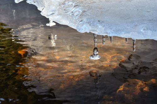 Free Detailed view of ice formations hanging over water with reflections Stock Photo