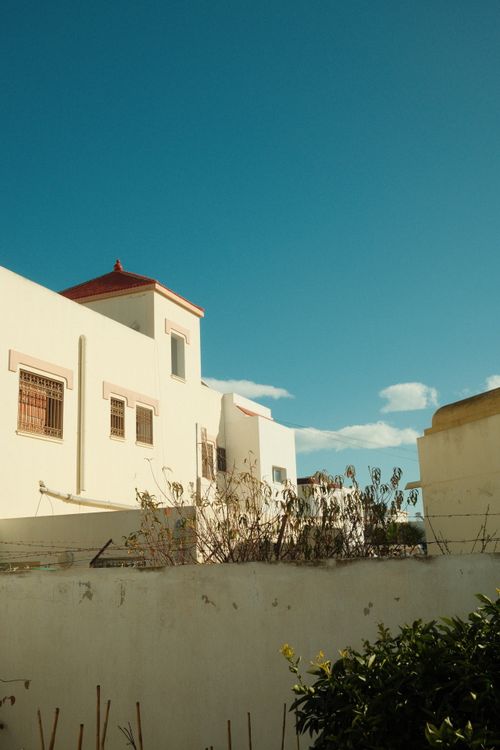 Free View of traditional Tunisian architecture under a clear blue sky, featuring iconic white and red structures. Stock Photo