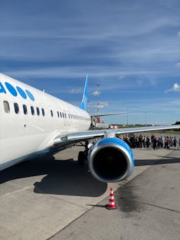Passengers boarding a plane on a sunny day at Kaliningrad Airport.