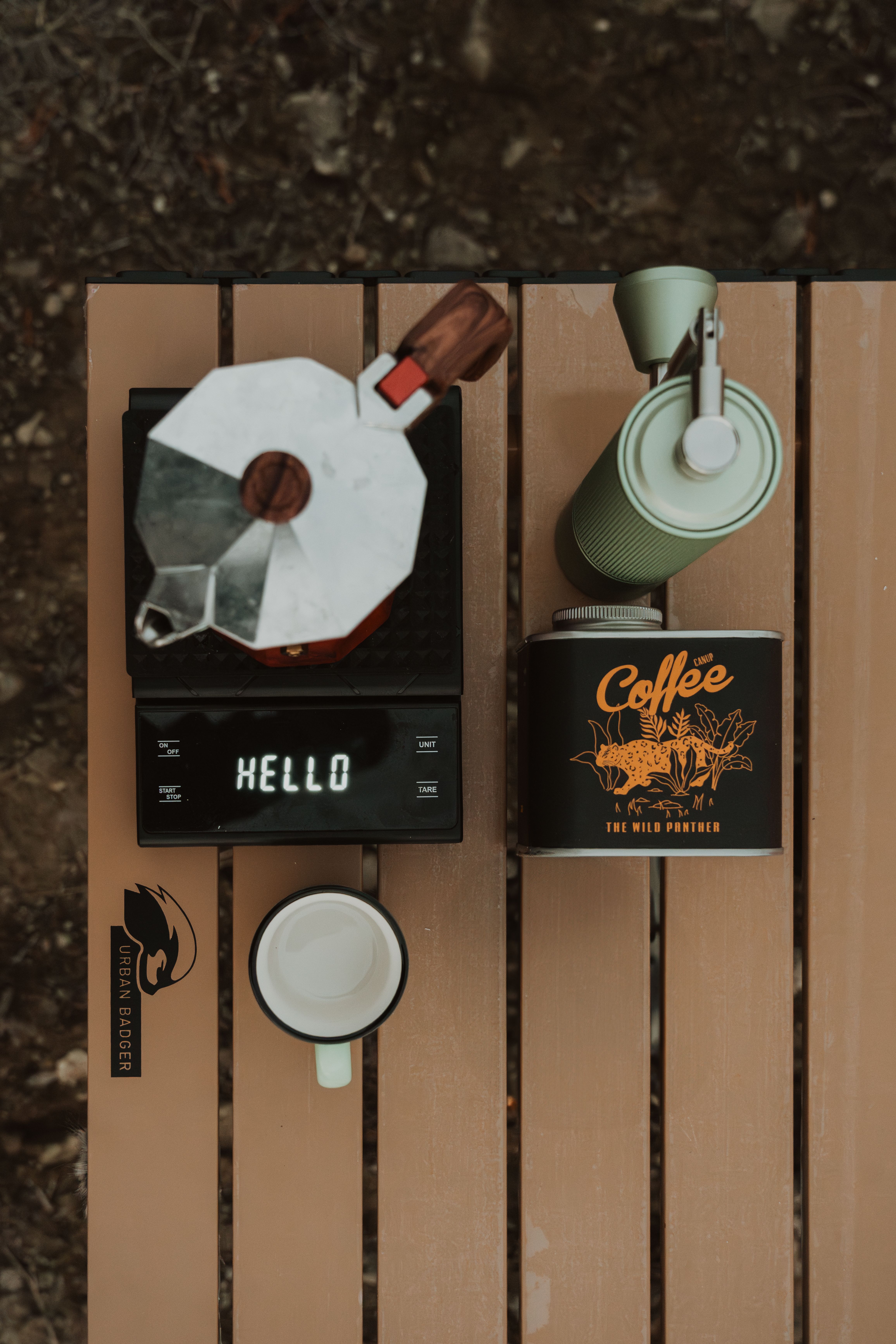 Flat lay of organized camping gear on a picnic table with labeled bins and a notebook checklist
