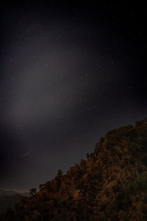 Free A breathtaking view of the starry night sky over a lush mountain landscape, capturing the serene beauty of nature. Stock Photo