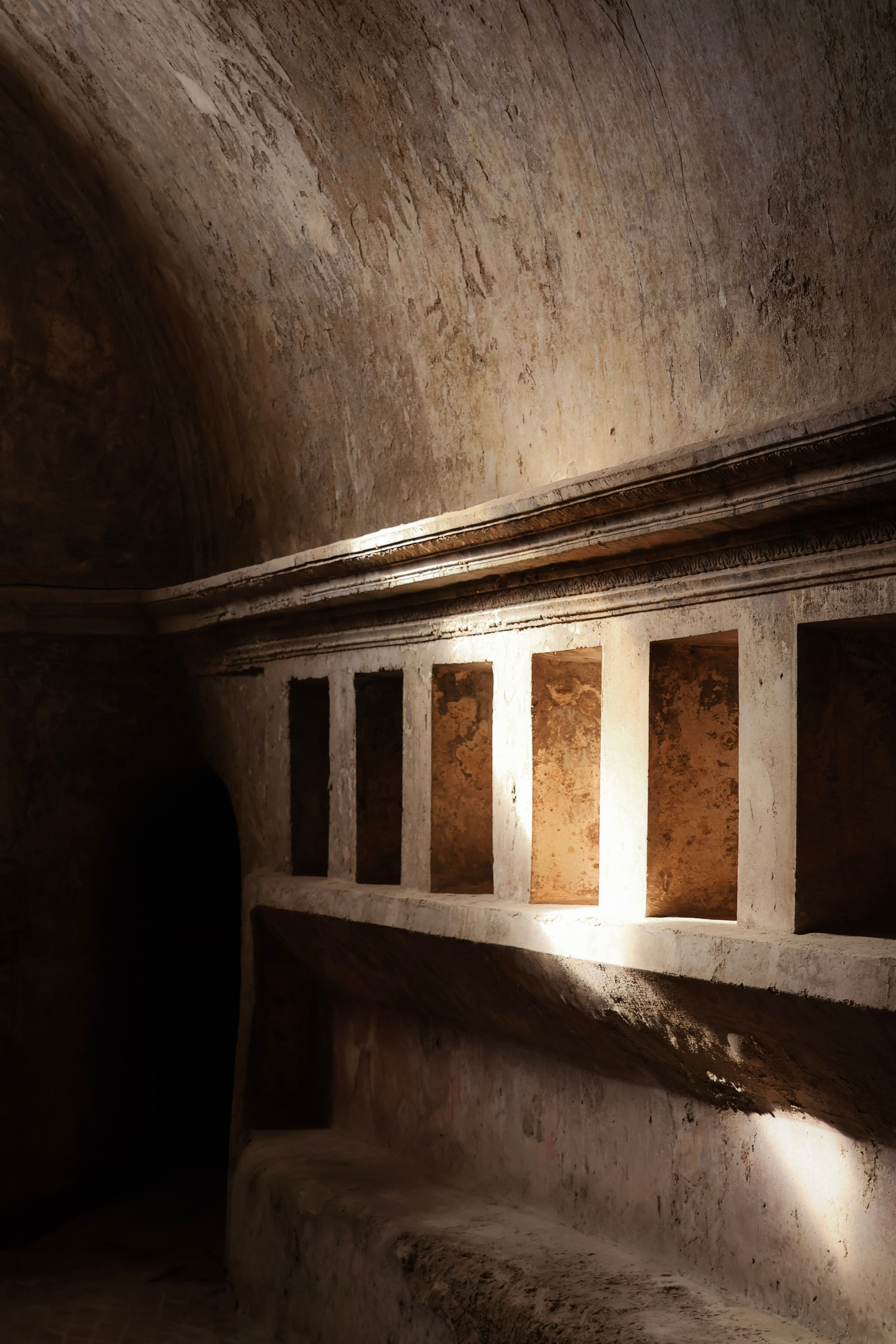 Explore the warm light and shadow play within ancient Roman architecture in Pompeii.