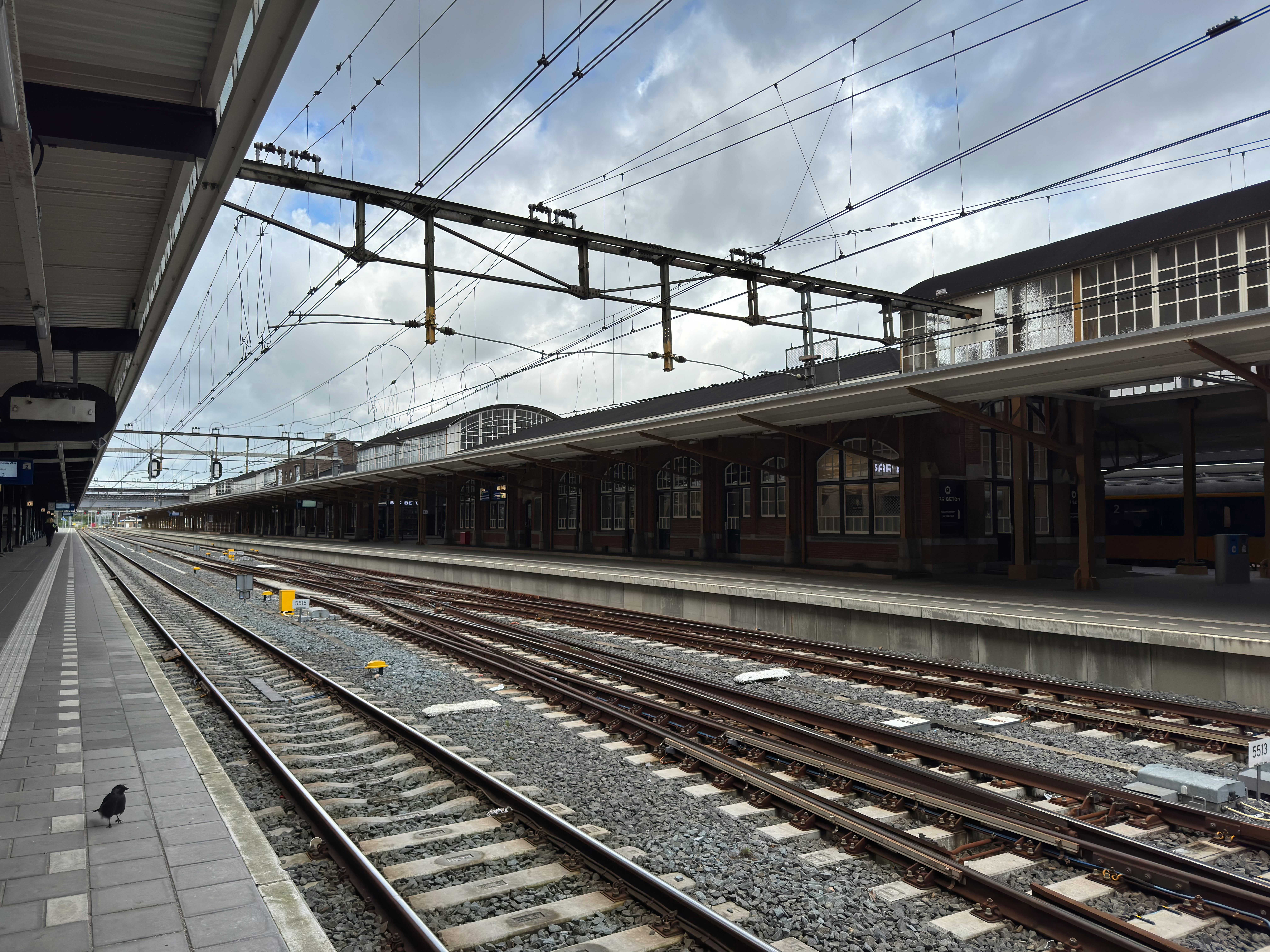 A deserted railway station platform at Amersfoort station, Netherlands, on a cloudy day.