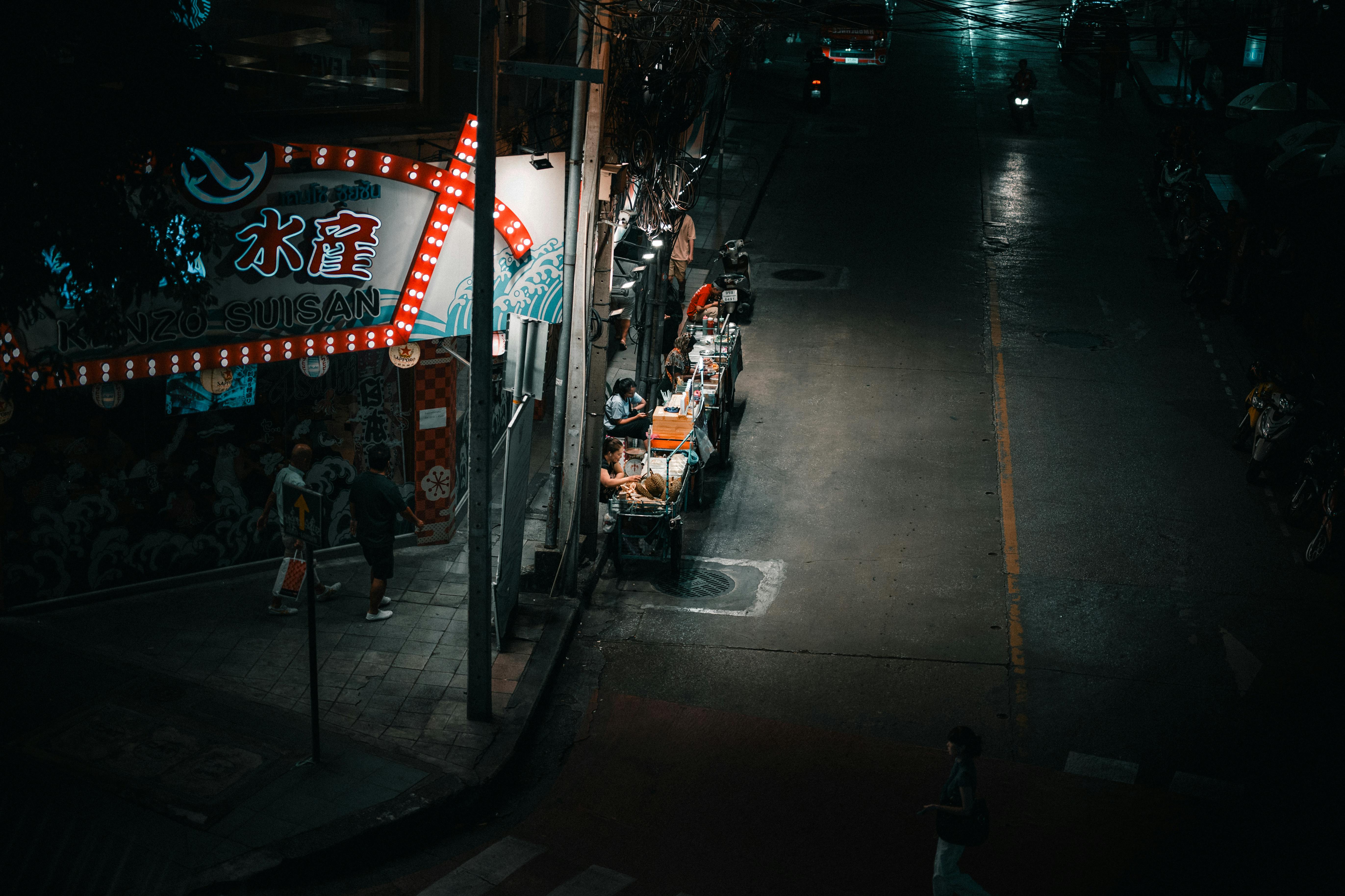 Gratuit O tarabă vibrantă cu mâncare stradală, iluminată noaptea, în Bangkok, Thailanda, cu oameni care se bucură de bucătăria locală. Fotografie de stoc