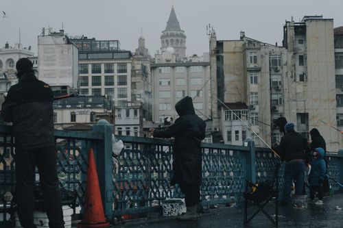 Free Fishermen on the Galata Bridge in Istanbul with cityscape and Galata Tower in view. Stock Photo