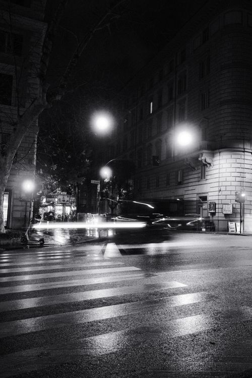 Free A moody black and white photograph of a city street at night with motion blur and bright lights. Stock Photo