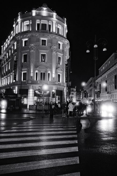 Free Black and white photo of a lively city street at night with historic architecture. Stock Photo